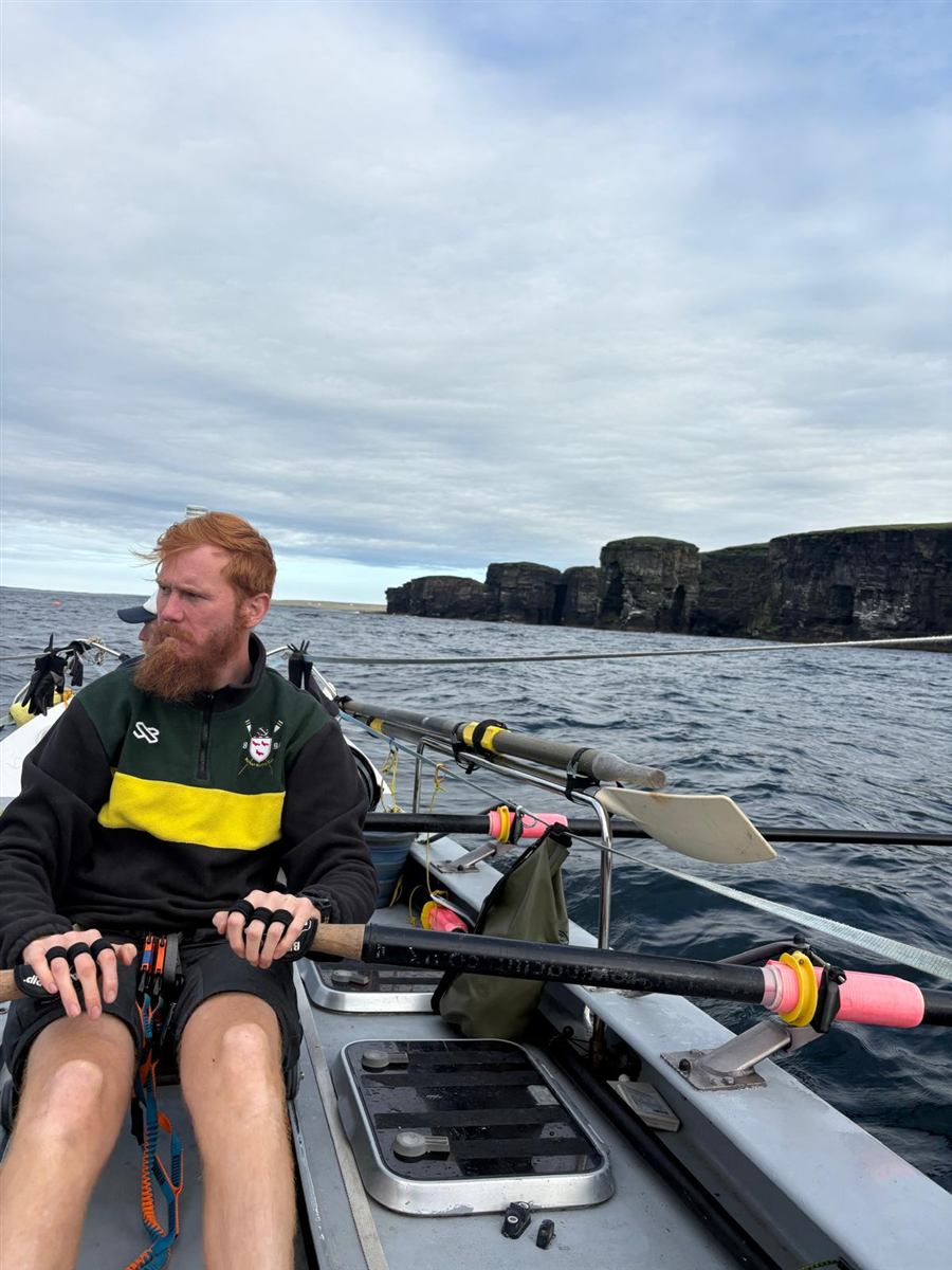 Scott on the GB row, Cornish cliffs in the background